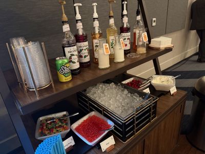 The dirty soda bar: rows of Monin syrups, a bin of ice, bowls of gummy bears and bobas, a can of Starry off to the side